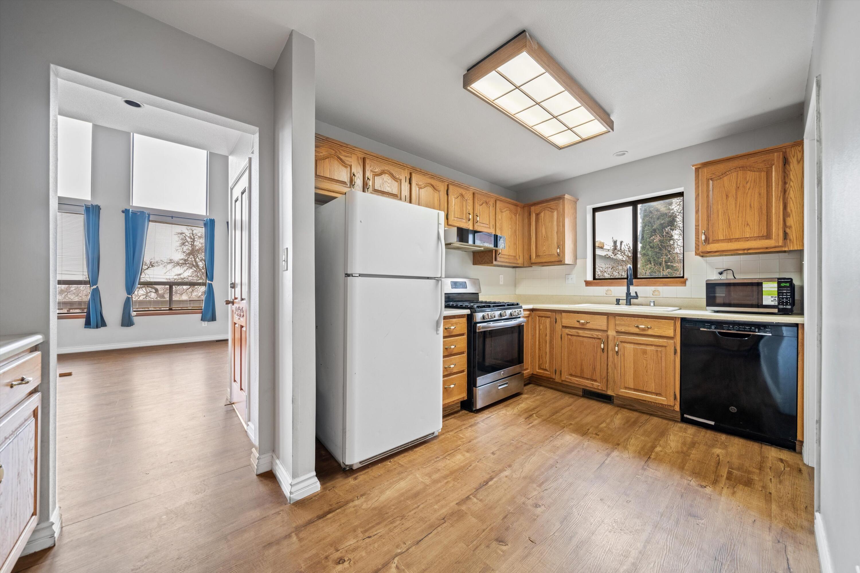 18249 Alps Drive Tehachapi, CA 93561 - Photo 29 of 32 a kitchen with a refrigerator a sink dishwasher with a dining table and chairs