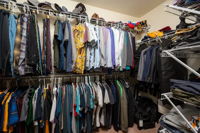 a view of walk in closet with clothes