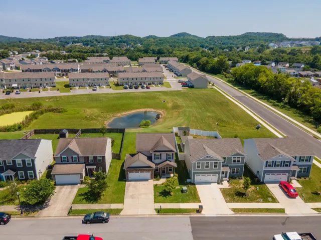 an aerial view of residential houses with outdoor space and swimming pool