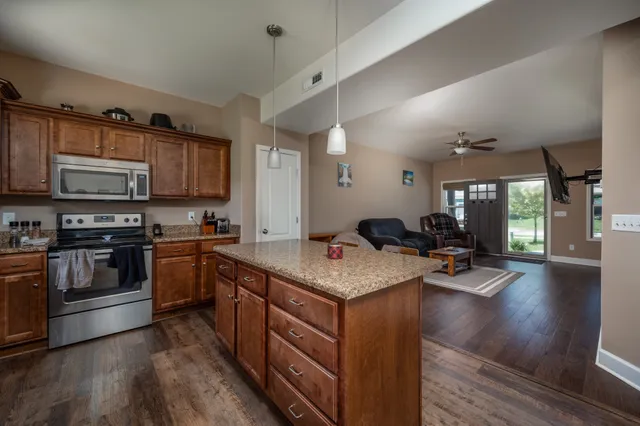a kitchen with stainless steel appliances granite countertop a sink stove and wooden cabinets