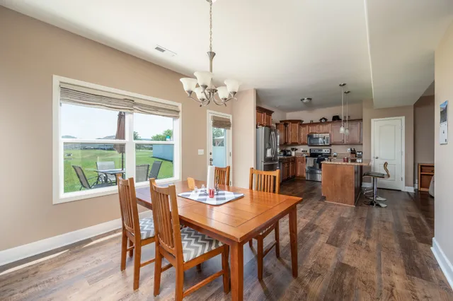 a dining room with furniture a chandelier and wooden floor