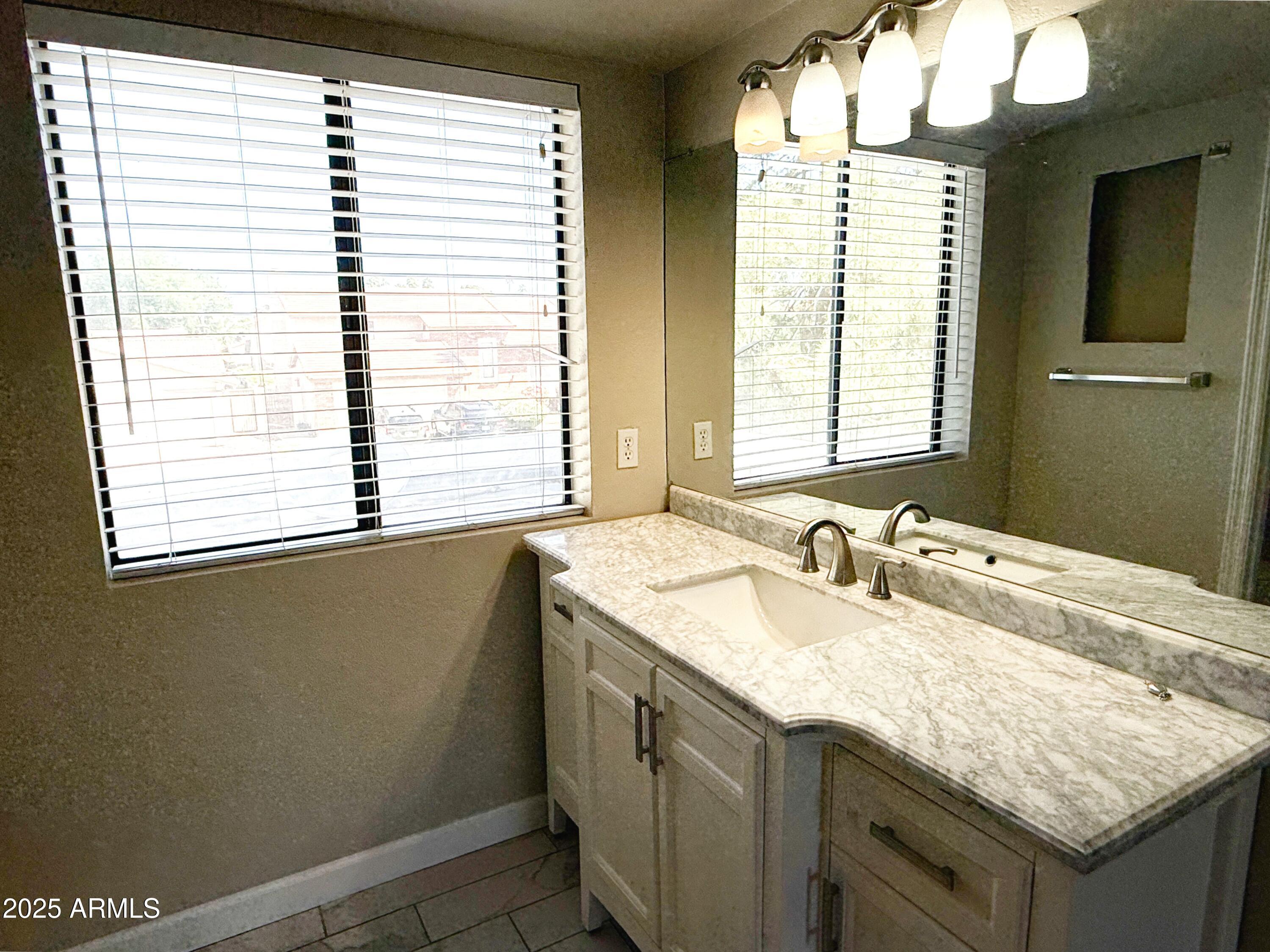1529 East Edgewater Drive Tempe, AZ 85283 - Photo 15 of 34 a bathroom with a granite countertop sink and a window