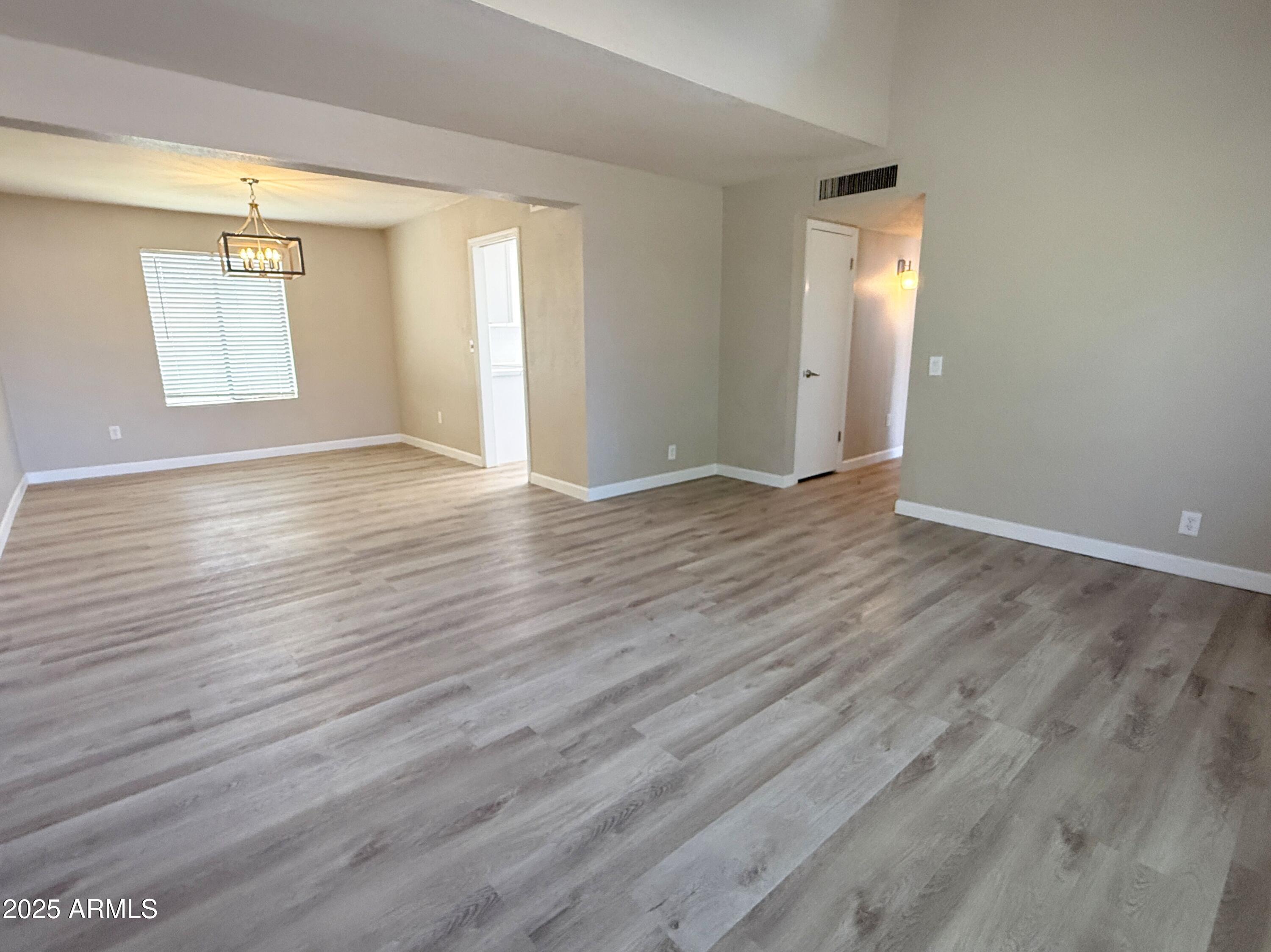 1529 East Edgewater Drive Tempe, AZ 85283 - Photo 2 of 34 an empty room with wooden floor and windows