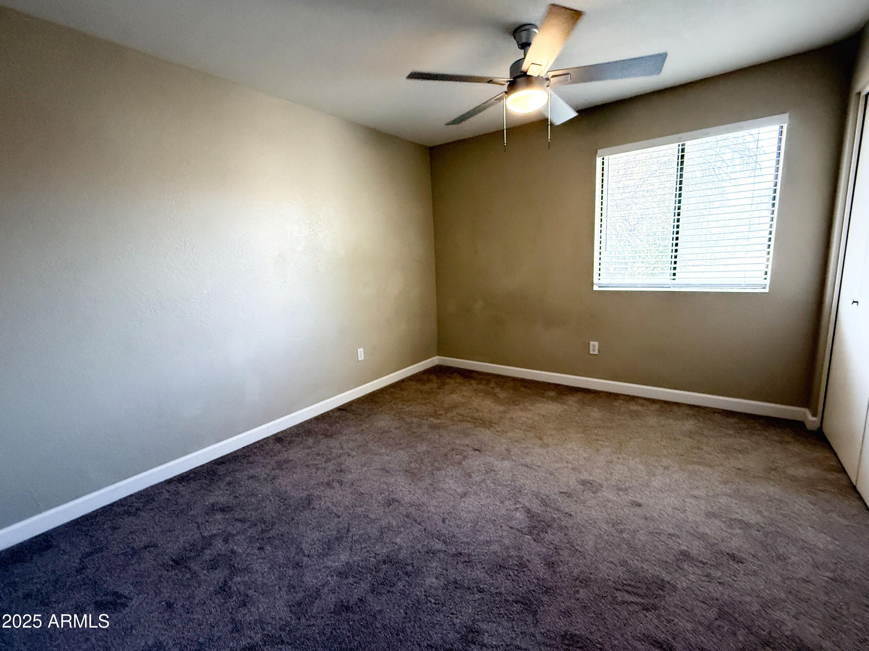1529 East Edgewater Drive Tempe, AZ 85283 - Photo 21 of 34 an empty room with a window and a fan