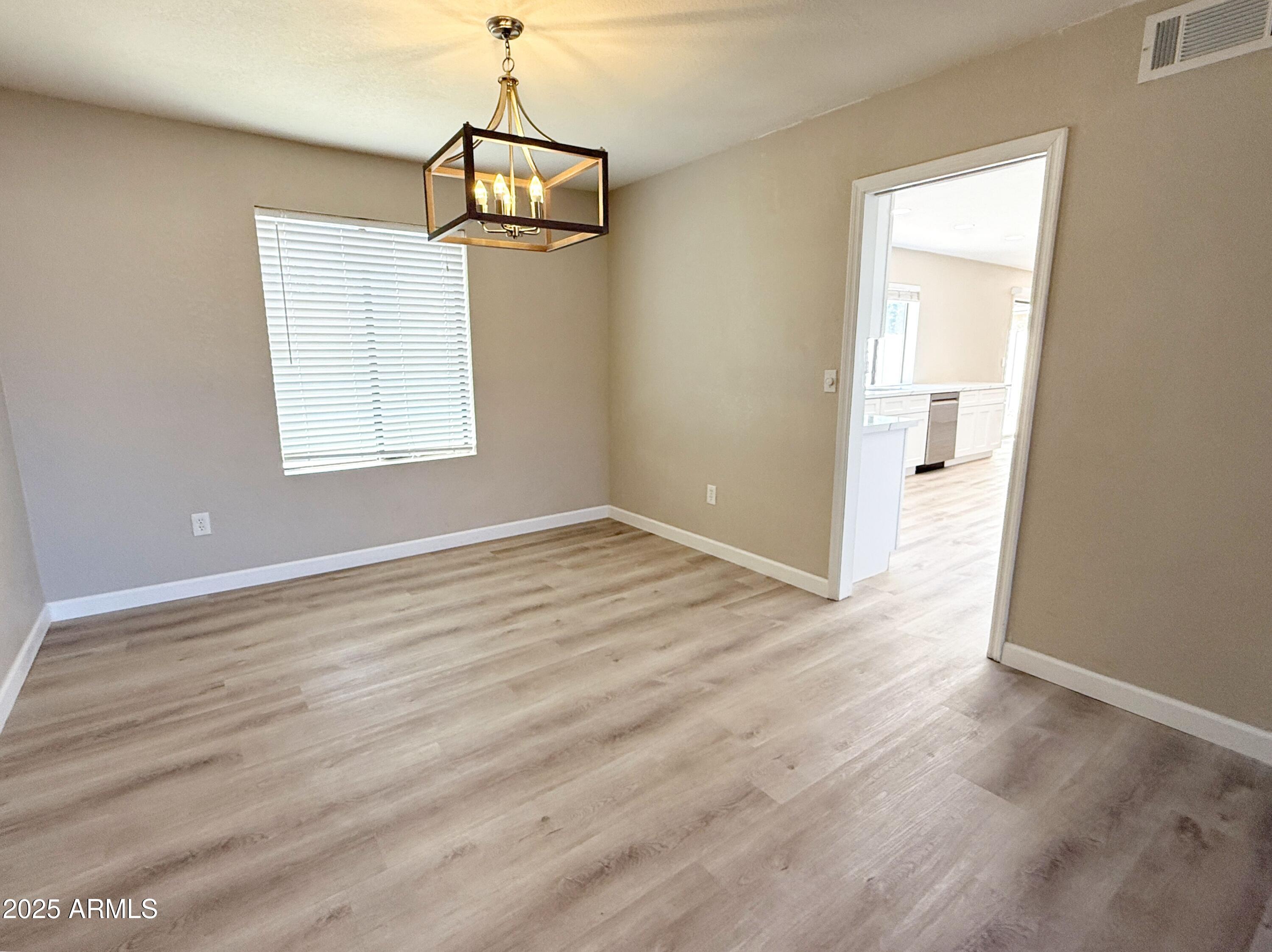 1529 East Edgewater Drive Tempe, AZ 85283 - Photo 4 of 34 an empty room with wooden floor and windows