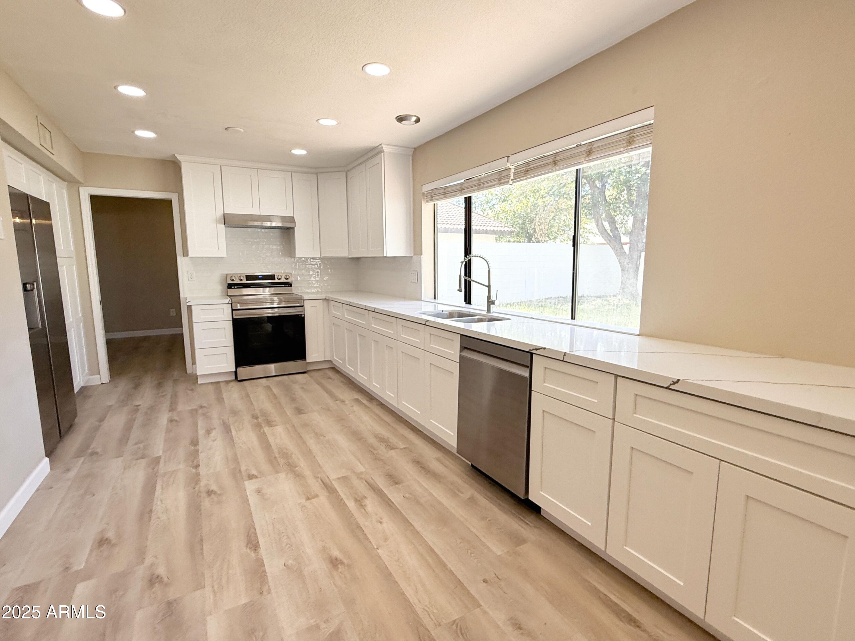 1529 East Edgewater Drive Tempe, AZ 85283 - Photo 8 of 34 a kitchen with stainless steel appliances granite countertop a stove a sink and a refrigerator