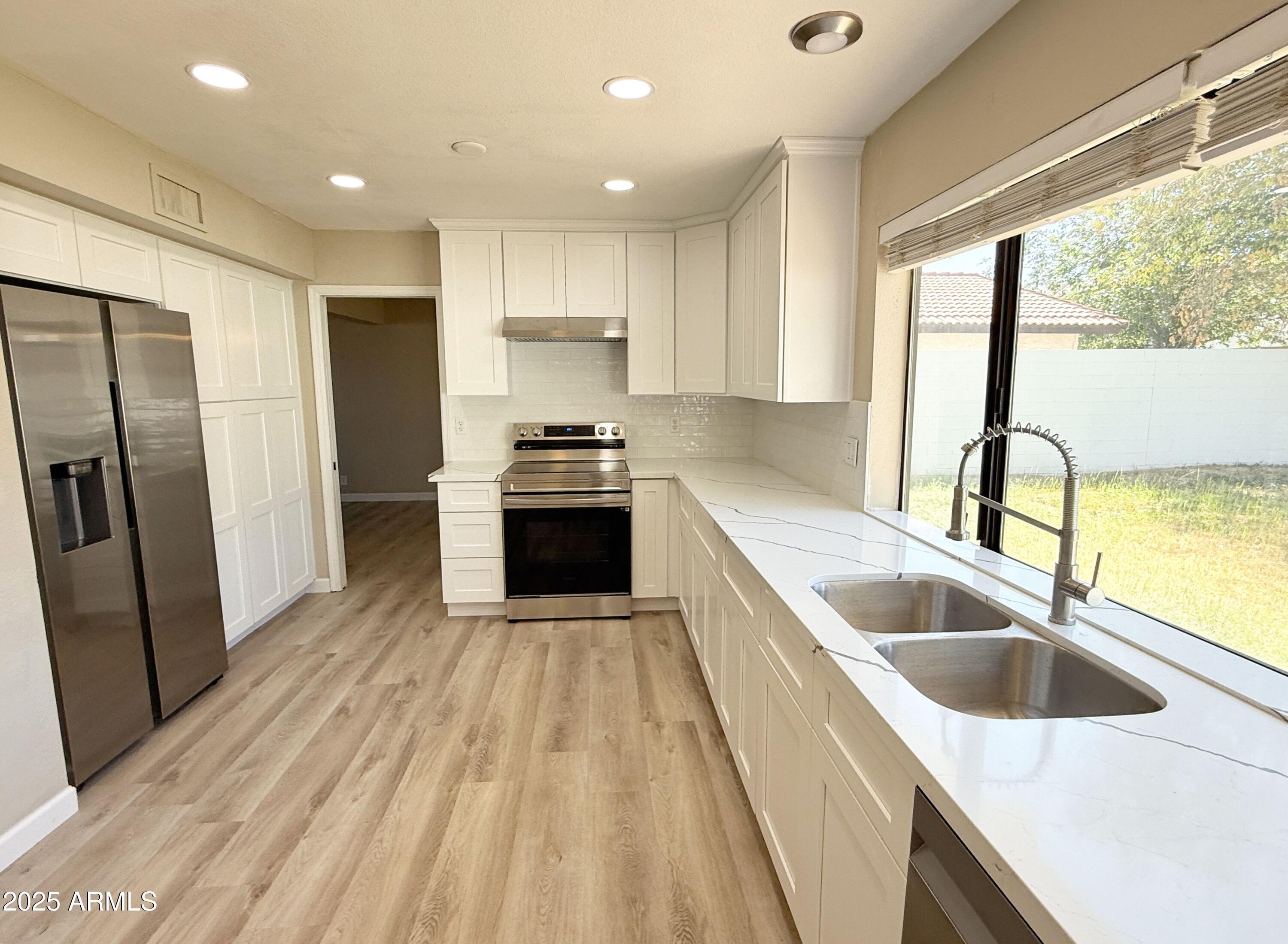 1529 East Edgewater Drive Tempe, AZ 85283 - Photo 9 of 34 a kitchen with stainless steel appliances granite countertop a sink stove and refrigerator