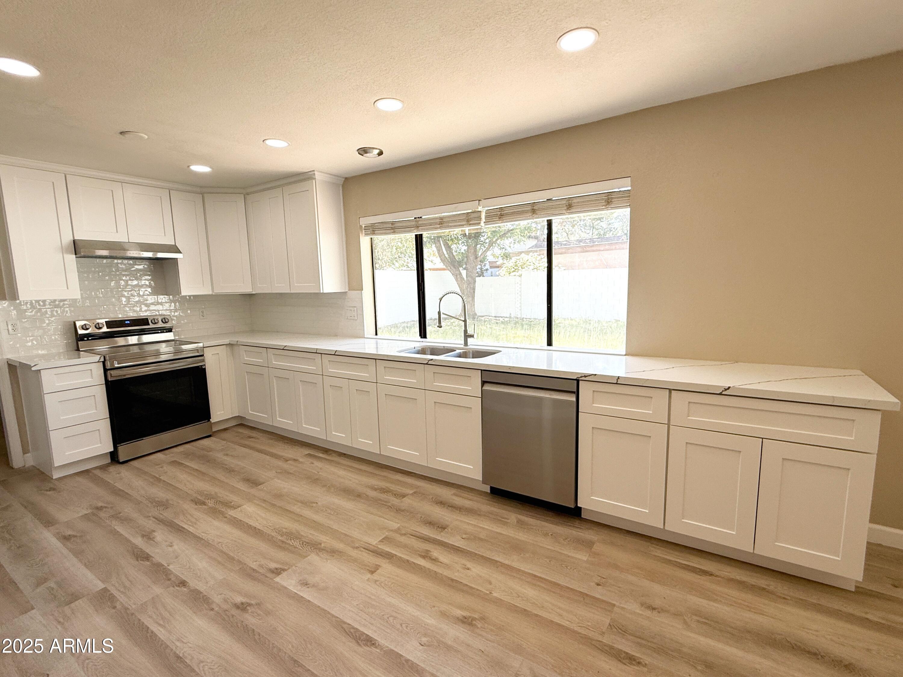 1529 East Edgewater Drive Tempe, AZ 85283 - Photo 10 of 34 a kitchen with granite countertop white cabinets and white appliances