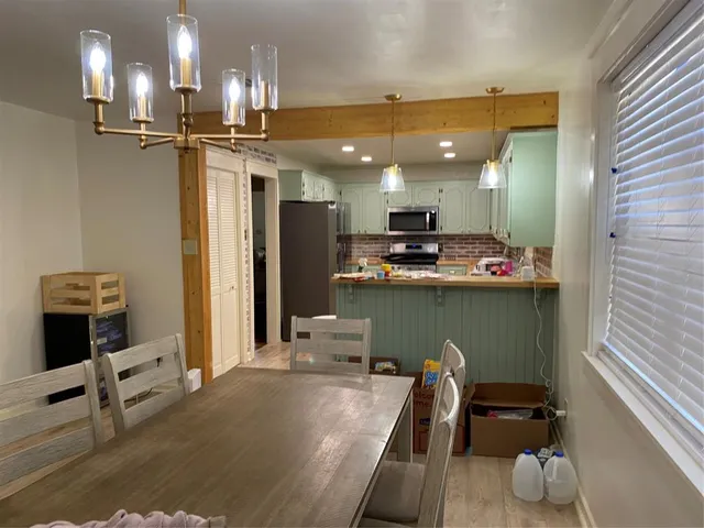 a kitchen with kitchen island stainless steel appliances a sink stove and refrigerator