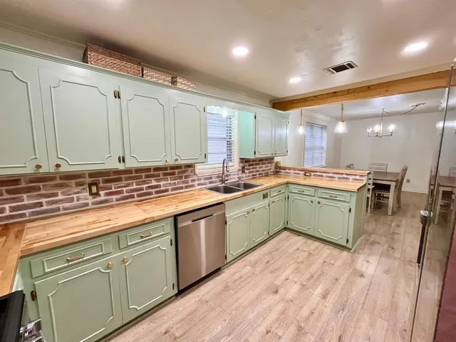 a kitchen with a sink cabinets and wooden floor