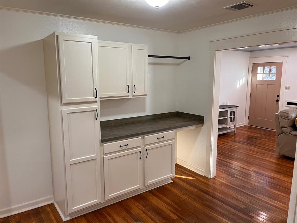 2802 Westover Road Shreveport, LA 71108 - Photo 9 of 33 a kitchen with wooden floors and white cabinets