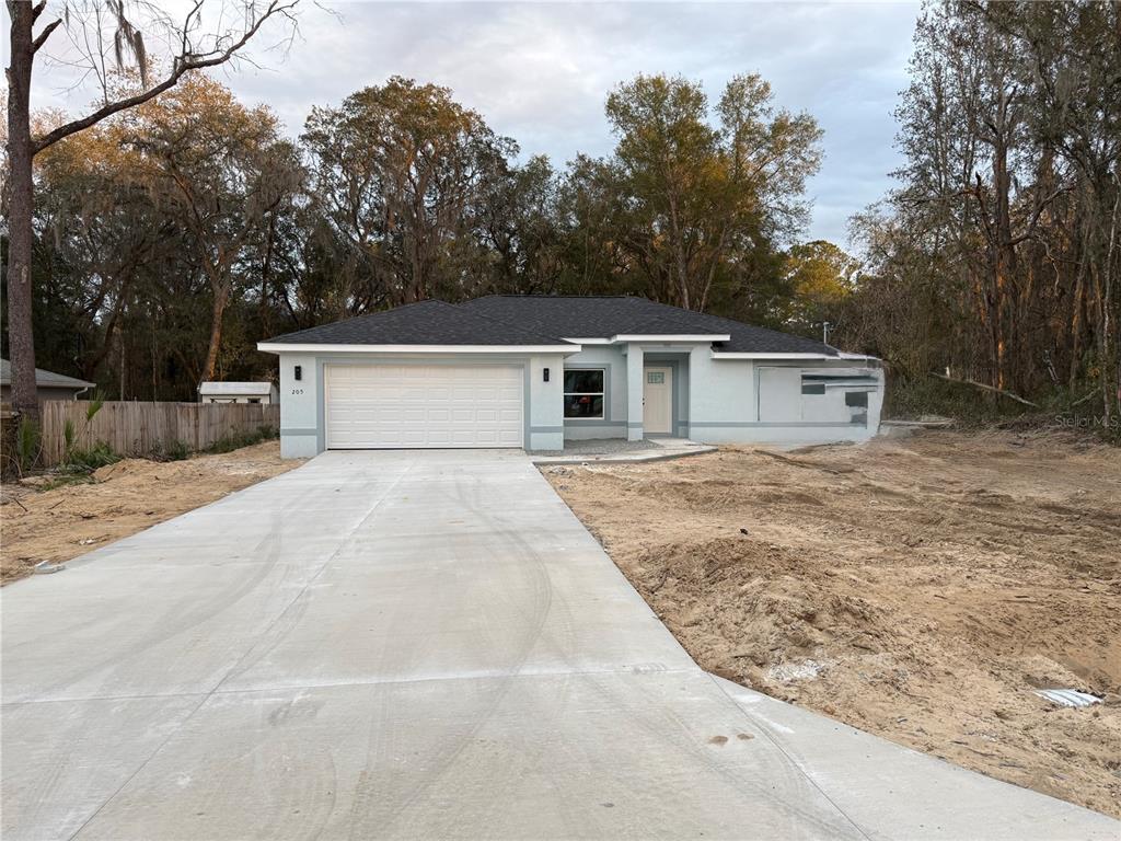 a view of house with outdoor space and trees in the background
