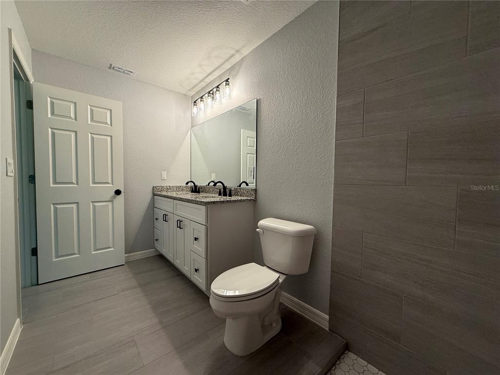 205 Emerald Road Ocala, FL 34472 - Photo 11 of 18 a bathroom with a toilet a sink and mirror