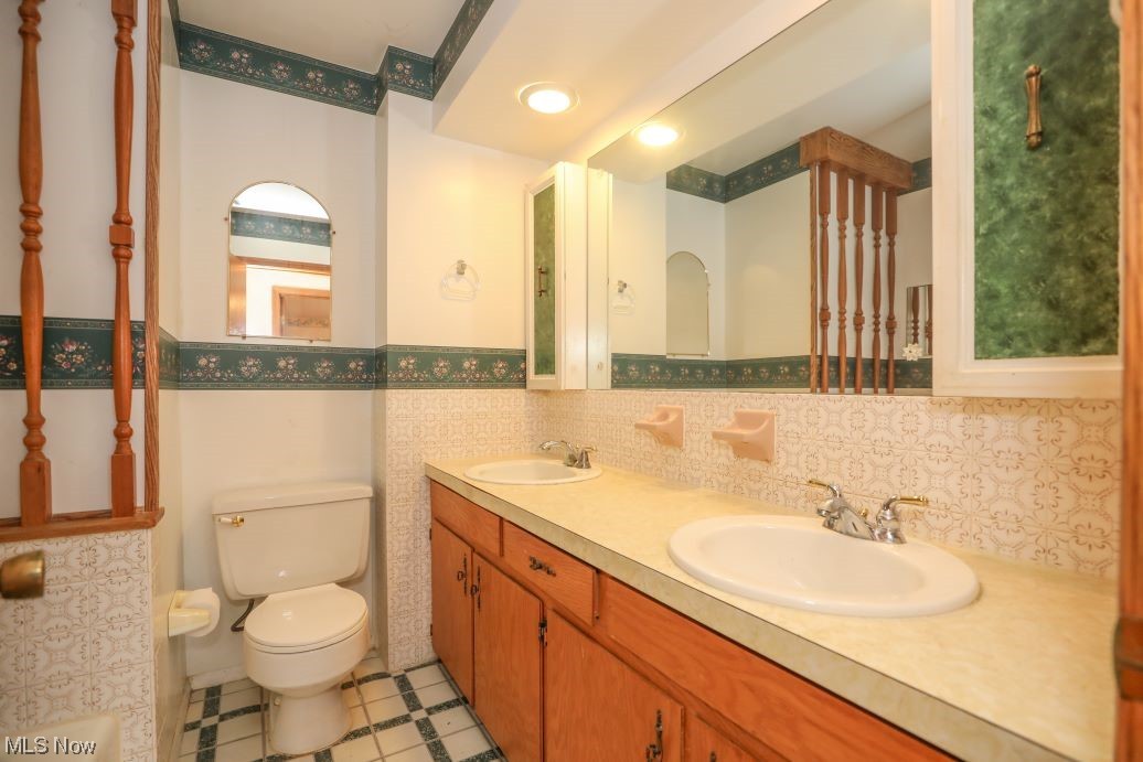 3143 Sandy Lake Road Ravenna, OH 44266 - Photo 32 of 35 Bathroom featuring tile floors, toilet, tasteful backsplash, and dual vanity
