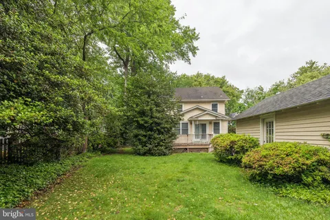 a view of a house with a small yard and wooden floor and fence
