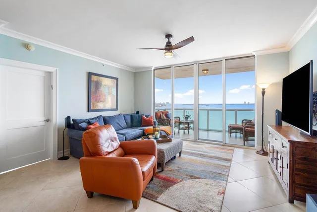 a living room with furniture a flat screen tv and a large window