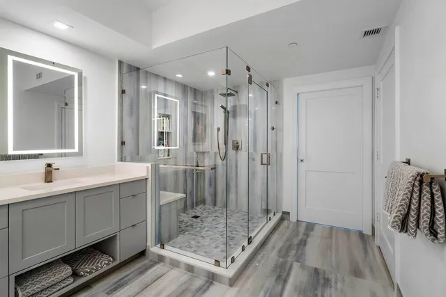 a bathroom with a double vanity sink mirror and shower