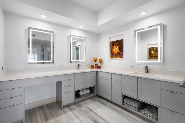 a spacious bathroom with double vanity and a mirror