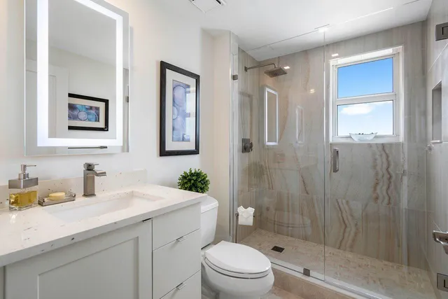 a bathroom with a sink a toilet and shower