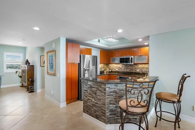 a kitchen with stainless steel appliances granite countertop a refrigerator and a stove top oven
