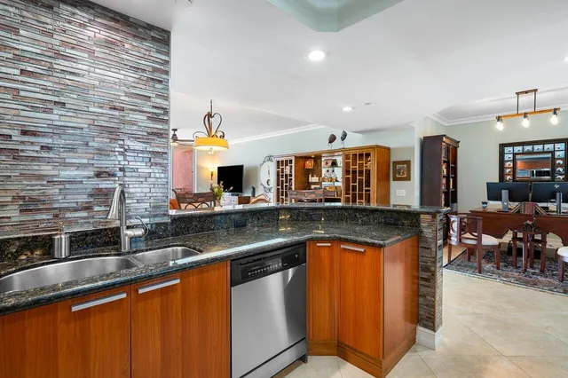a kitchen with stainless steel appliances granite countertop a sink a stove counter space and cabinets