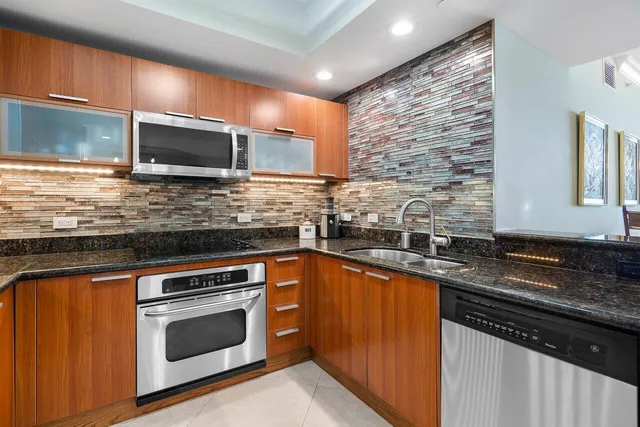 a kitchen with stainless steel appliances granite countertop a sink stove and microwave