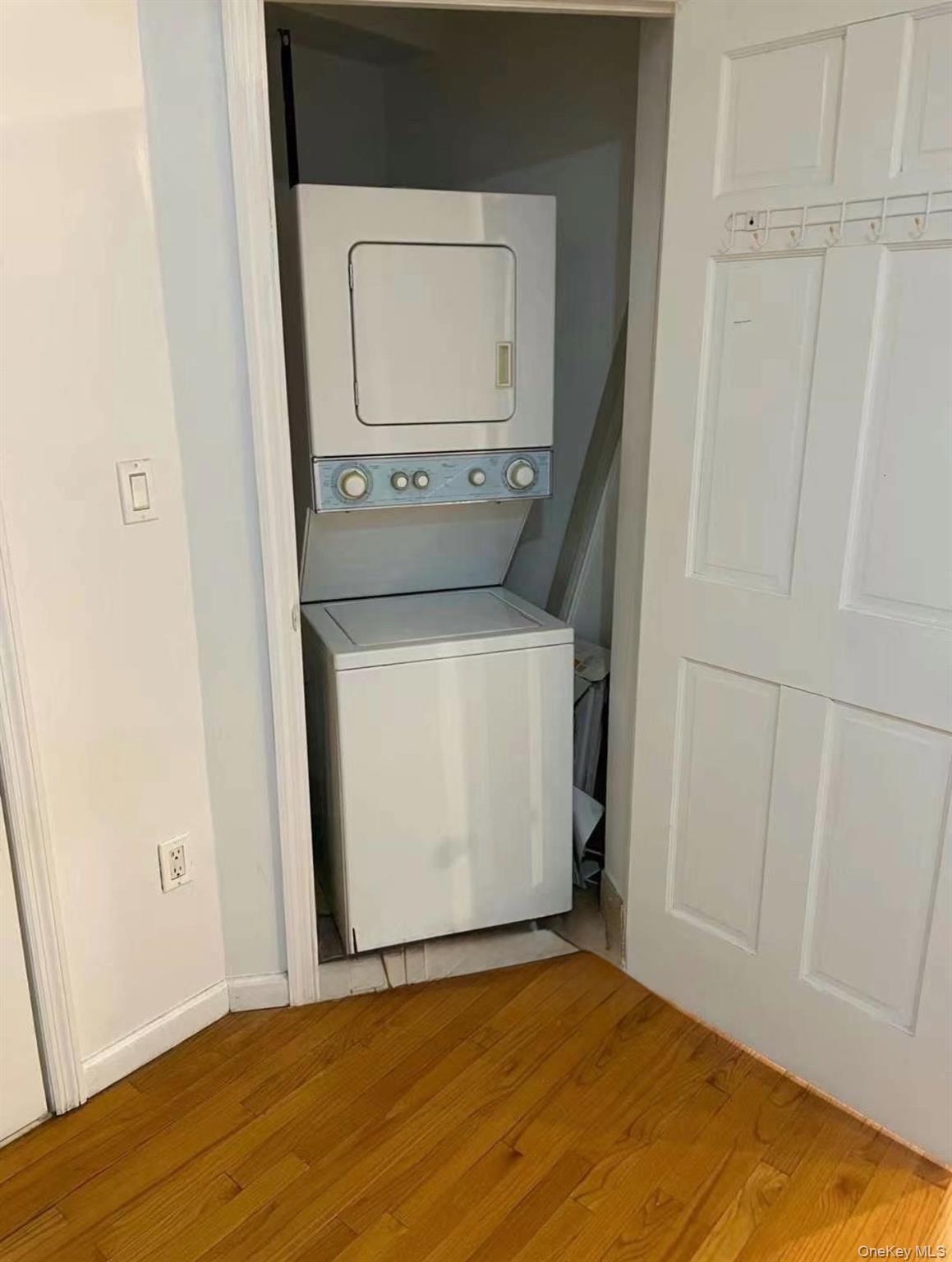 137-08 31st Road, Unit 5D Queens, NY 11354 - Photo 4 of 4 Laundry room featuring stacked washer / drying machine and light wood-style flooring