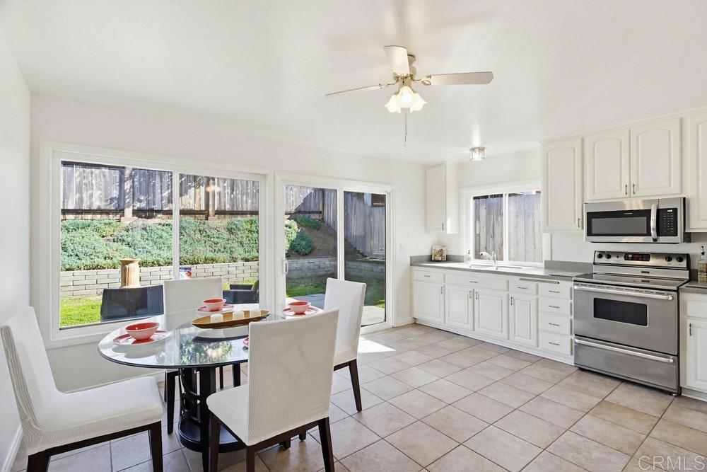 13001 Standish Drive Poway, CA 92064 - Photo 7 of 36 a kitchen with a stove a sink a kitchen island with a dining table and chairs