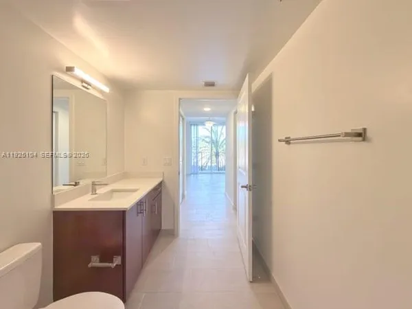 a bathroom with a sink a toilet a mirror and shower