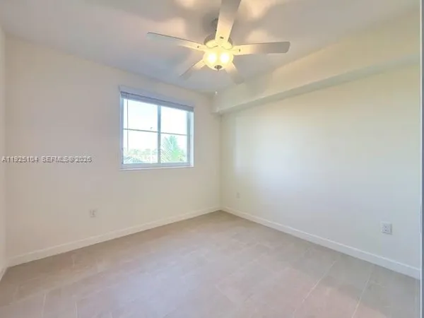 an empty room with a window and a fan