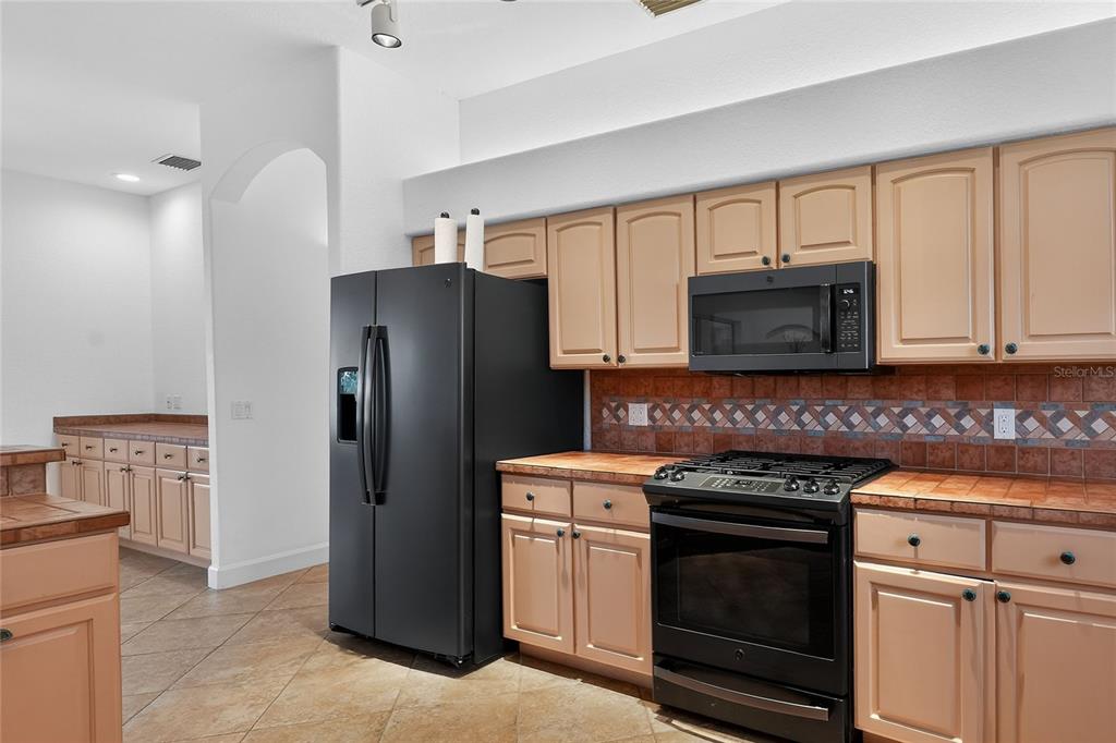 2968 Plantation Road Winter Haven, FL 33884 - Photo 21 of 81 a kitchen with white cabinets and stainless steel appliances