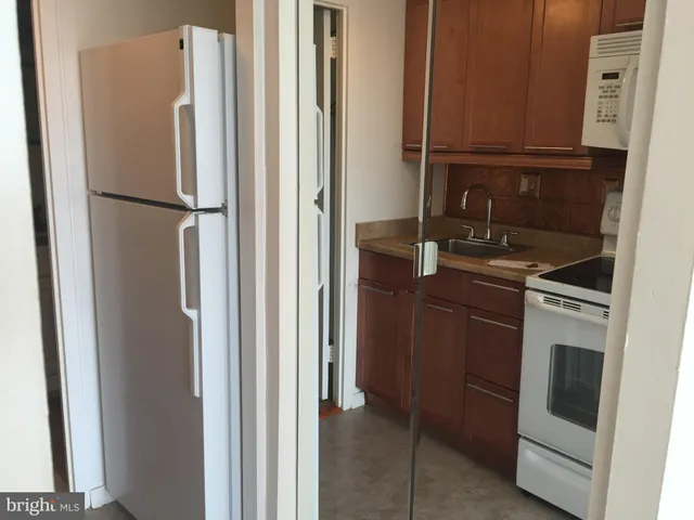 a kitchen with a refrigerator sink and cabinets
