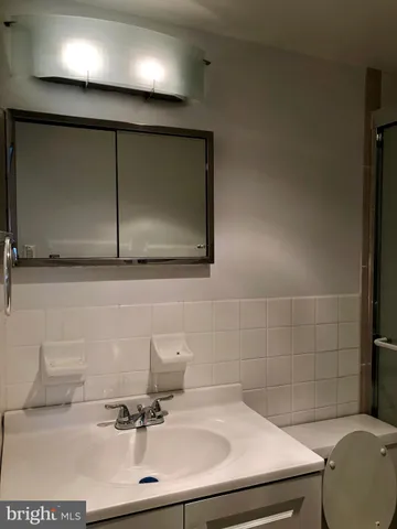 a bathroom with a sink a toilet and a mirror