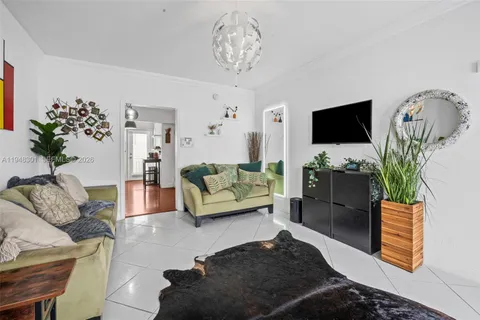 a living room with furniture a flat screen tv and a potted plant