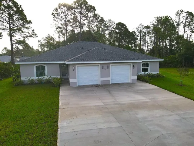 a view of a house with a yard and a garage