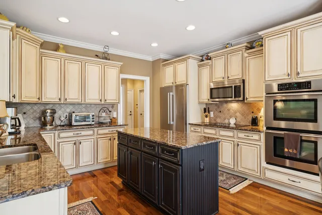 a large kitchen with kitchen island granite countertop a sink stove and refrigerator