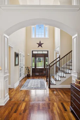 a view of a hallway with wooden floor and staircase
