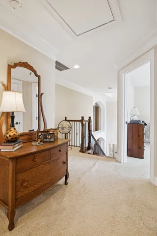 a bedroom with a bed a dresser and a chandelier