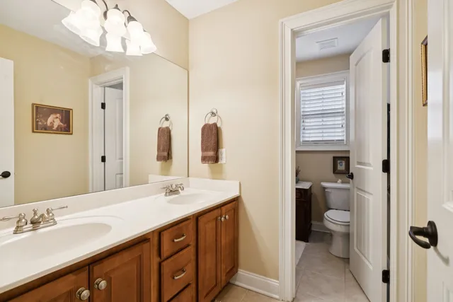 a spacious bedroom with a large bed a chandelier and closet