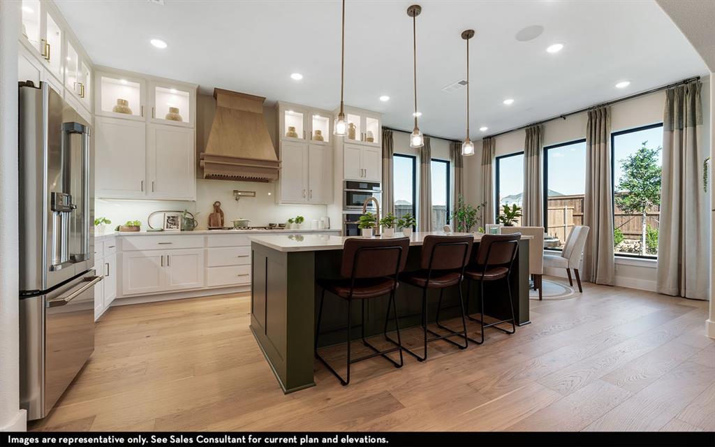 16301 Flatlands Way Celina, TX 75009 - Photo 17 of 39 a kitchen with a table chairs refrigerator and microwave