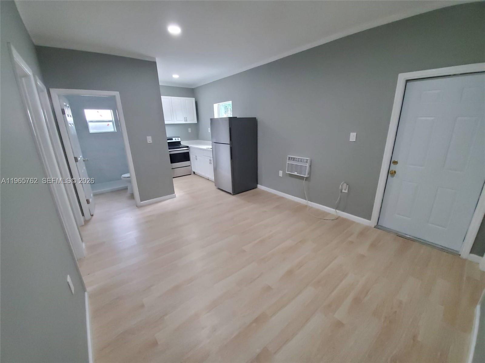 2425 Northwest 28th Street Miami, FL 33142 - Photo 16 of 18 a view of a kitchen with furniture and an empty room