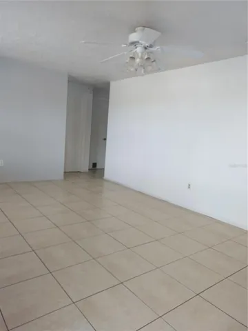 an empty room with a chandelier fan
