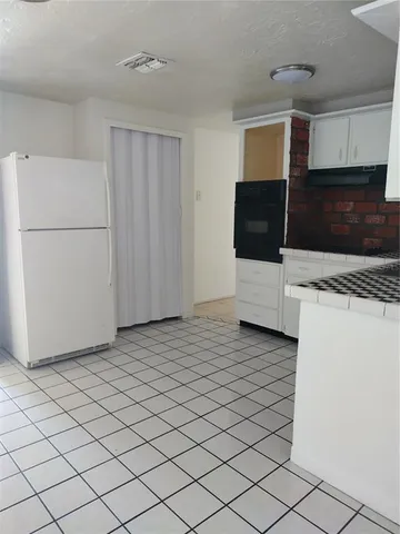 a kitchen with a refrigerator and a stove top oven