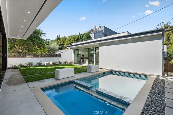 a living room with furniture kitchen view and a potted plant