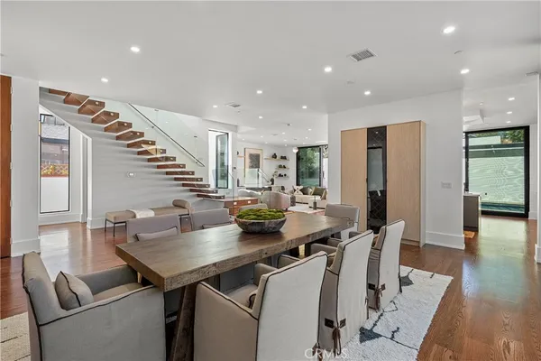 a living room with furniture a floor to ceiling window and potted plant
