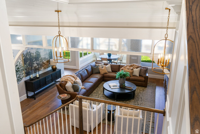 115 East Hidden Ridge Lane, Unit 42 Mapleton, UT 84664 - Photo 55 of 103 Spacious living area featuring wood-finish flooring, high ceilings, multiple windows, and two decorative ceiling light fixtures