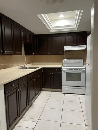 a kitchen with a stove sink and cabinets