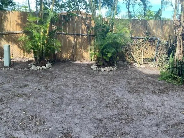 a view of a yard with plants and trees