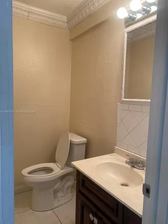 a bathroom with a toilet a sink and mirror