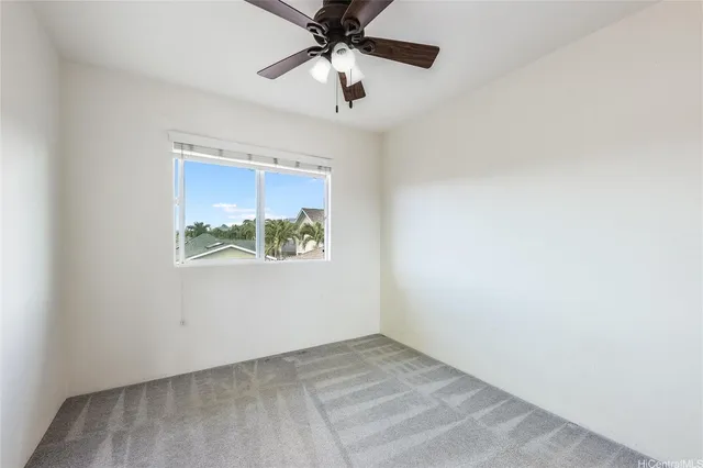 an empty room with a window and a ceiling fan